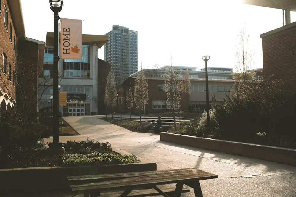 A sunny campus scene with buildings and pathways, illustrating connected institutions